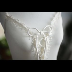 Ivory coloured slip or dress. Rose filigree motif edging a lace up style bodice.